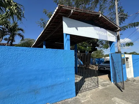 Muro azul e portão aberto do Centro Educacional Pré-Escolar Luís da Câmara Cascudo, sem fila na entrada