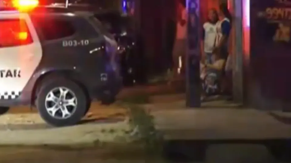 Viatura da Polícia Militar estacionada à noite em frente ao local do crime no Parque das Árvores, em Parnamirim